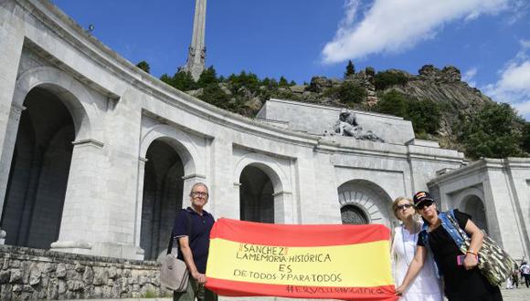 Manifestantes posan con una bandera española donde se lee "Sánchez, la memoria histórica pertenece a todos y todas". (Foto: AFP)