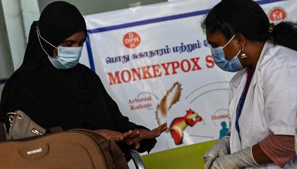 Los trabajadores de la salud examinan a los pasajeros que llegan del extranjero para detectar síntomas de viruela del mono en la terminal del Aeropuerto Internacional Anna en Chennai el 3 de junio de 2022. (Foto de Arun SANKAR / AFP)