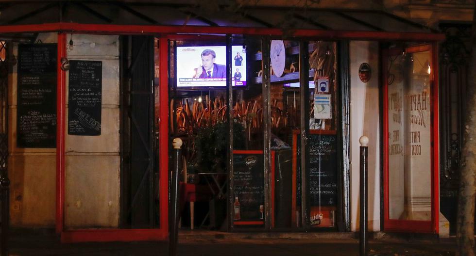 El presidente de Francia, Emmanuel Macron, es visto en una pantalla de televisión en un bar cerrado en París, el 14 de octubre de 2020. (REUTERS/Gonzalo Fuentes).