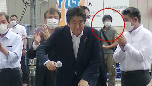 El ex primer ministro japonés Shinzo Abe asistiendo a una campaña electoral antes de dar un discurso en la plaza de la estación Kintetsu Yamato-Saidaiji en Nara, mientras el sospechoso de dispararle está detrás. (Foto: AFP)