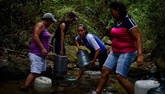 La gente llena los recipientes con agua de un arroyo en la montaña Wuaraira Repano, también llamada "El Ávila", en Caracas. (Foto: AFP)