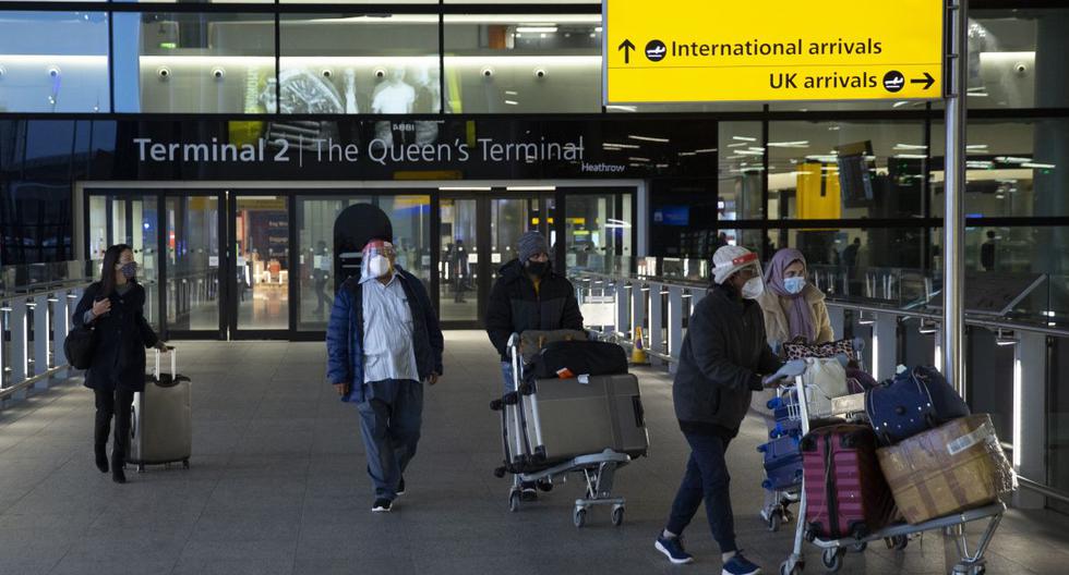 Las personas empujan su equipaje al salir del área de llegadas en el aeropuerto de Heathrow en Londres (Inglaterra), el martes 26 de enero de 2021. (AP/Matt Dunham).