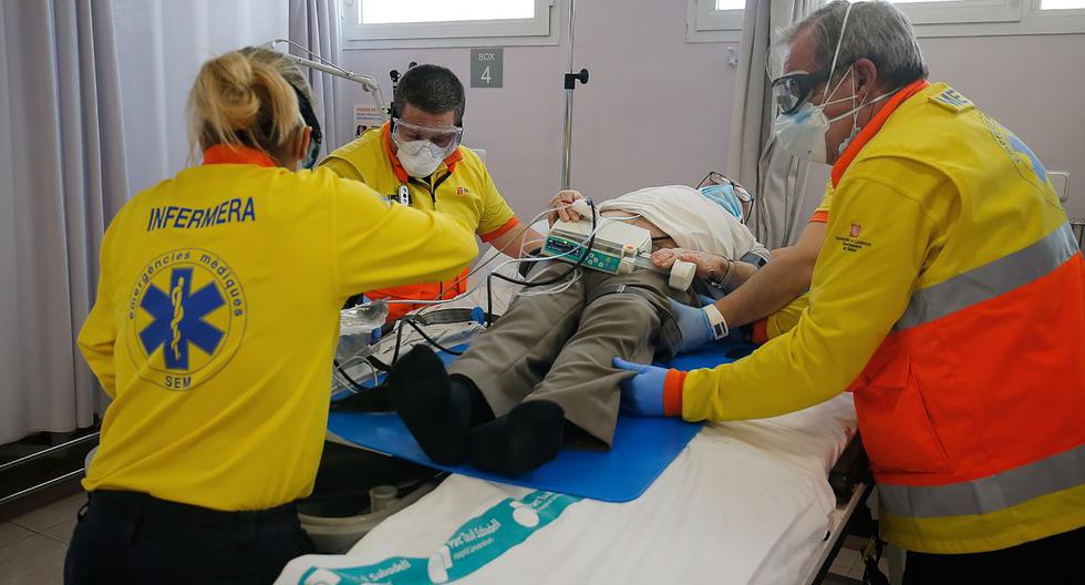 Imagen referencial. El 24 de abril de 2020, los trabajadores sanitarios de los Servicios Médicos de Emergencia de Cataluña (SEM) son vistos atendiendo a un paciente. (PAU BARRENA / AFP).