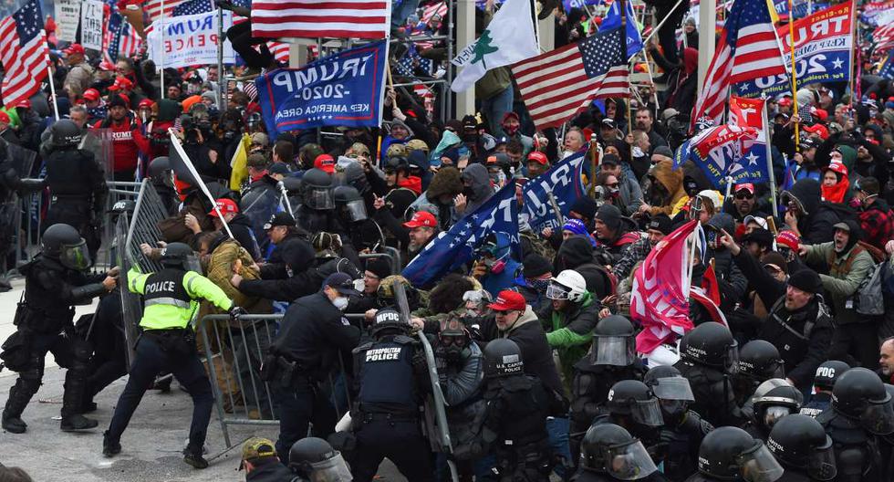 Los partidarios de Trump chocan con la policía y las fuerzas de seguridad mientras empujan barricadas para asaltar el Capitolio de los Estados Unidos, en Washington, el 6 de enero de 2021. (ROBERTO SCHMIDT / AFP).