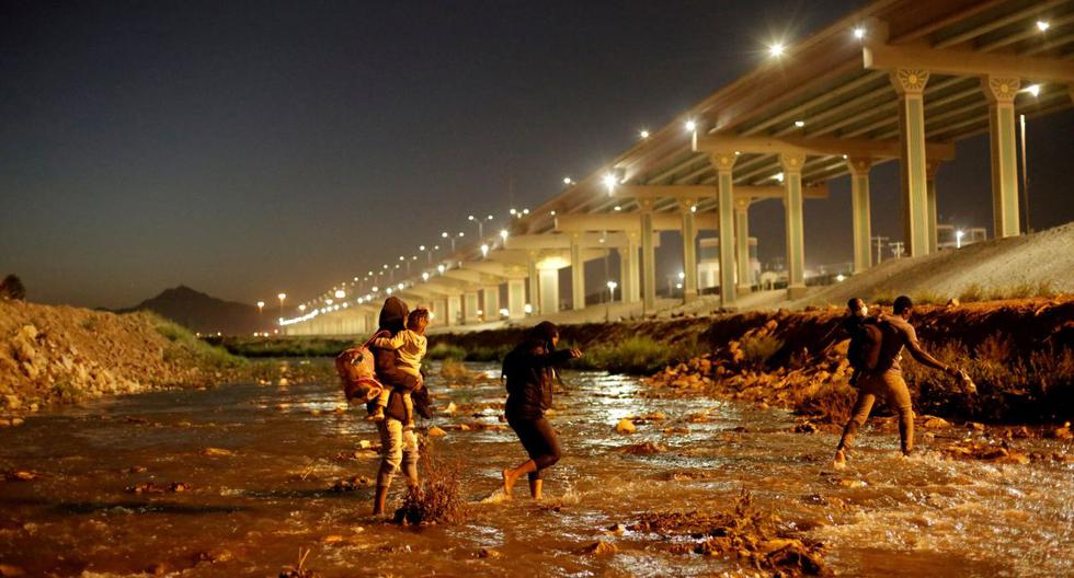Migrantes cruzan el río Bravo para entregarse a agentes de la Patrulla Fronteriza de Estados Unidos para solicitar asilo en El Paso, Texas. Imagen vista desde Ciudad Juárez, México, el 19 de marzo de 2021. (REUTERS/Jose Luis Gonzalez).
