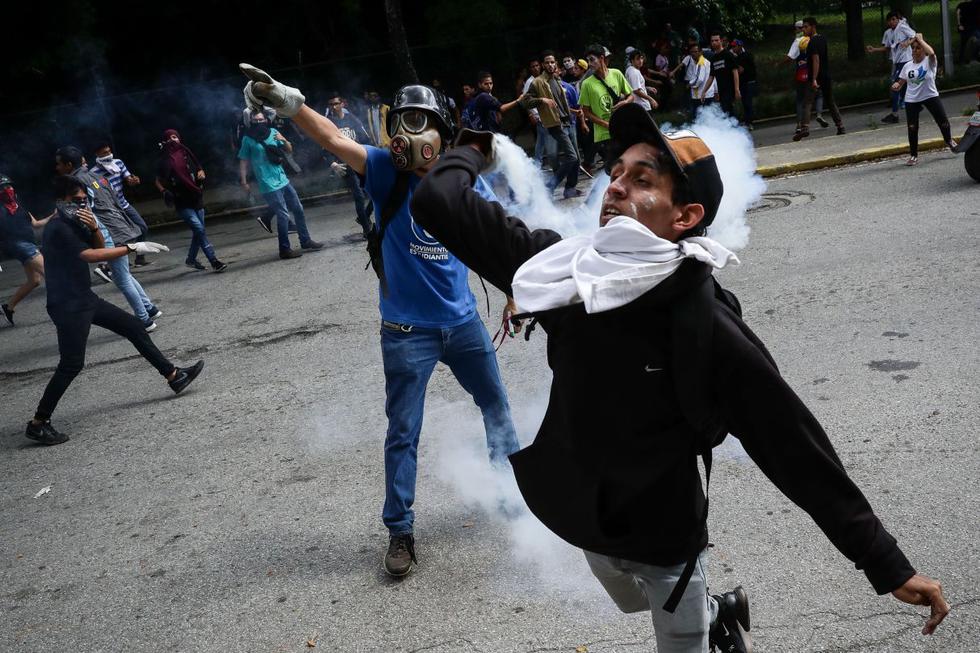 Decenas de jóvenes caminaron con flores blancas en las manos hasta el lugar donde un grupo de funcionarios de la Policía Nacional Bolivariana (PNB) bloqueó la vía e impidió la continuidad de esta movilización que contó en los primeros minutos con la presencia del jefe del Parlamento y líder opositor, Juan Guaidó. (Foto: EFE)