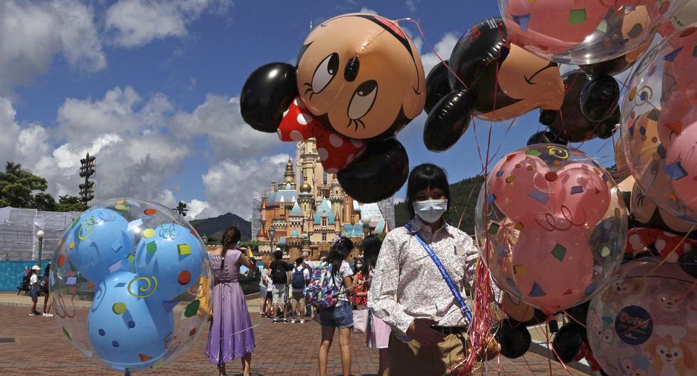 Un empleado, que usa una máscara facial para prevenir la propagación del nuevo coronavirus, vende globos en Hong Kong Disneyland. Imagel del jueves 18 de junio de 2020.  (AP/Kin Cheung).