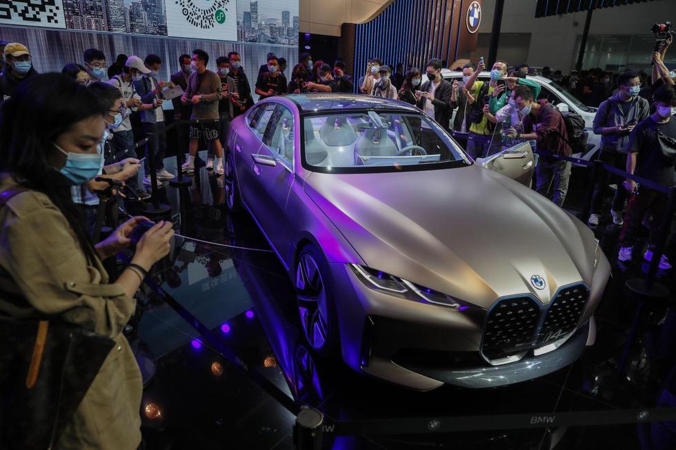 El automóvil BMW i4 se observa rodeado de personas en la Exposición Automotriz Internacional de Beijing, China. (EFE/EPA/WU HONG).