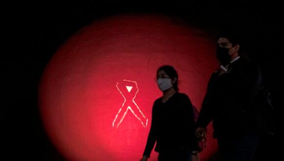 Foto referencial de una pareja camina por el Centro Cultural Tijuana (CECUT) mientras su cúpula está iluminada en rosa como parte del Mes de Concientización sobre el Cáncer de Mama, en Tijuana, México. (Foto: Guillermo ARIAS / AFP)