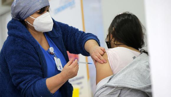 Una mujer recibe una dosis de la vacuna Pfizer-BioNTech contra el coronavirus en un centro de vacunación de Santiago, el 12 de julio de 2021. (Foto de JAVIER TORRES / AFP).