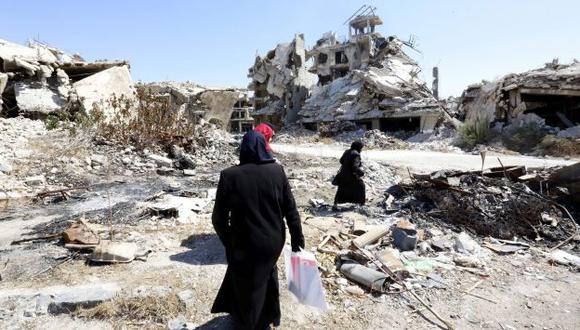 Mujeres sirias caminan entre las ruinas de la ciudad Homs, Siria. (EFE)