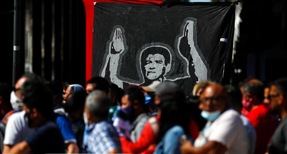 Una pancarta que representa a la leyenda del fútbol Diego Maradona aparece en la foto mientras la gente espera en la fila frente a la Casa Rosada, en Buenos Aires, Argentina. (REUTERS/Agustin Marcarian).