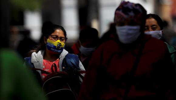 En la imagen, personas con mascarilla caminan por una calle, en la ciudad de Quito, la ciudad más afectada por la pandemia. (EFE)