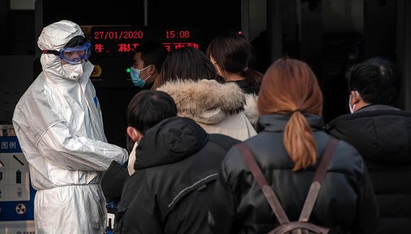 Un personal de seguridad verifica la temperatura de las personas con una cámara termográfica avanzada (no representada) en la entrada de una estación de metro en Beijing. (Foto: AFP)