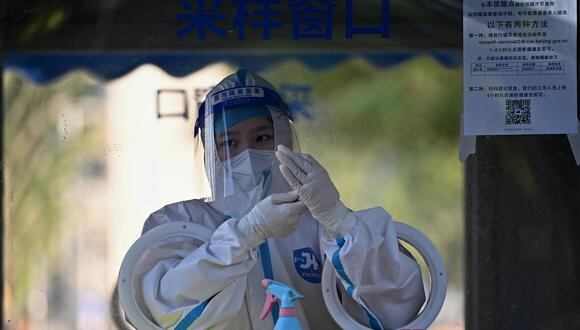 Se ve a un trabajador de la salud en una cabina de recolección de hisopos para el coronavirus Covid-19 en Beijing el 6 de julio de 2022. (Foto de Noel Celis / AFP)