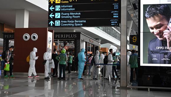 Pasajeros con equipo de protección personal (PPE) contra el coronavirus en el aeropuerto internacional Sukarno Hatta en Tangerang el 8 de junio de 2021 (Foto referencial: ADEK BERRY / AFP)