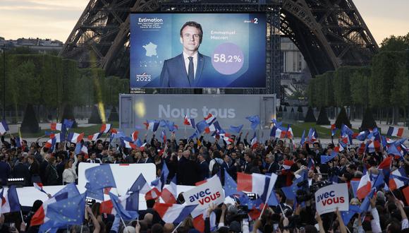 Los partidarios reaccionan después de la victoria del presidente francés y el candidato del partido La Republique en Marche (LREM) para la reelección Emmanuel Macron en las elecciones presidenciales de Francia, en el Champ de Mars, en París, el 24 de abril de 2022. (Foto de Ludovic MARIN / AFP)