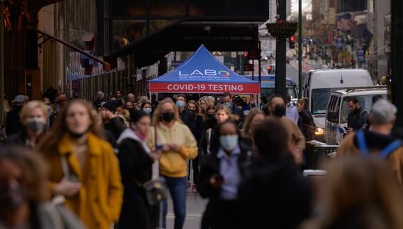 La gente pasa frente a un puesto de prueba de COVID-19 en una calle de la ciudad de Nueva York el 21 de diciembre de 2021. (Foto: Ed JONES / AFP)
