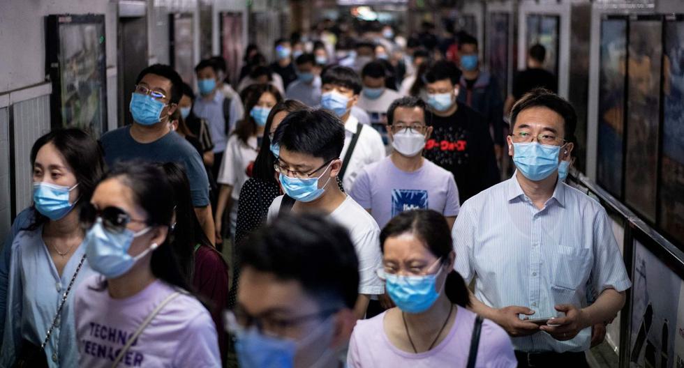 Las personas que usan máscaras faciales caminan en una estación de metro durante la hora pico de la mañana en Beijing. (AFP/NOEL CELIS).