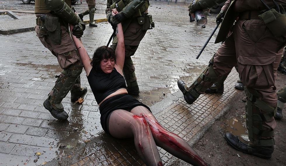 Una mujer manifestante es arrastrada por la policía en la Plaza Italia de Santiago de Chile. (Foto: EFE)