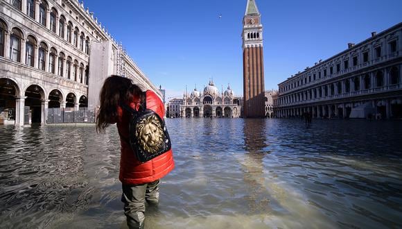 Una mujer camina por la inundada Plaza de San Marcos, con la Basílica de San Marcos (trasera) y el Campanario en Venecia. (Foto: AFP)