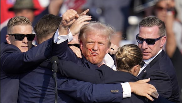 Donald Trump levanta el puño mientras es protegido por el Servicio Secreto tras un tiroteo en un mitin en Pensilvania. (AP / Gene J. Puskar).