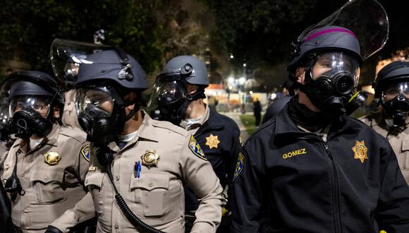Agentes de la policía estadounidense hacen guardia cerca de un campamento propalestino en el campus de la Universidad de California en Los Ángeles (UCLA), el 1 de mayo de 2024. (Foto de ETIENNE LAURENT / AFP)