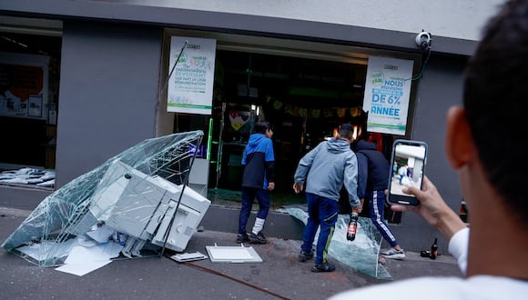 Gente irrumpe en un supermercado durante las protestas en Lille, en el norte de Francia, el 29 de junio de 2023, tras la muerte de un adolescente a manos de un policía en el suburbio parisino de Nanterre. (Foto de Kenzo TRIBOUILLARD / AFP)