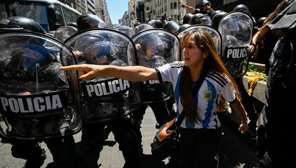 La policía antidisturbios choca con manifestantes después de una protesta convocada por la Confederación General del Trabajo (CGT) de Argentina contra el decreto de emergencia del presidente Javier Milei. (Foto de Luis ROBAYO/AFP).