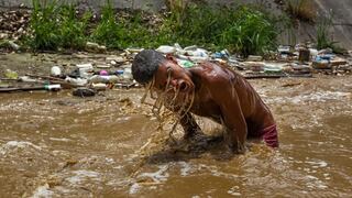 Desesperados por la crisis, jóvenes se buscan la vida entre las aguas fecales de Caracas [FOTOS]