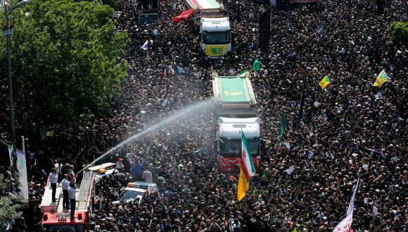 Bomberos iraníes rocían con agua a la multitud en el funeral del presidente Ebrahim Raisi en Teherán, Irán, este miércoles. EFE/ Abedin Taherkenareh