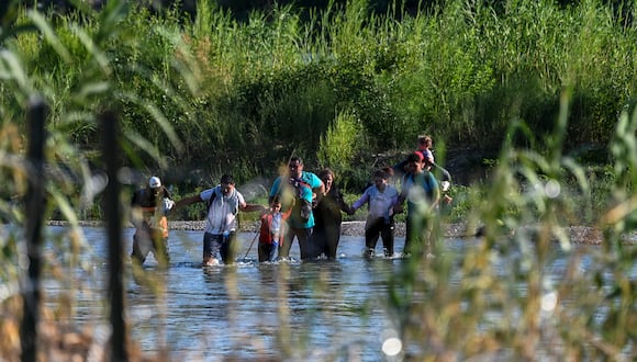 Una familia migrante de Venezuela cruza ilegalmente el Río Grande en Eagle Pass, Texas, en la frontera con México.