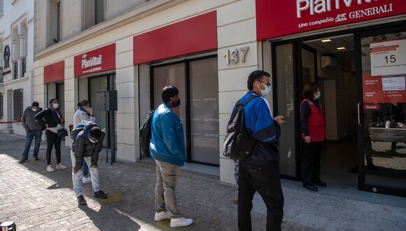Gente hace cola frente a la oficina de una Administradora de Fondos de Pensiones (AFP) para realizar trámites para retirar sus fondos en Santiago, el 26 de abril de 2021.  (Foto: Martin BERNETTI / AFP)