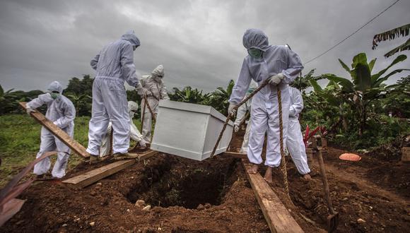 Trabajadores funerarios entierran a una víctima del coronavirus Covid-19 en un cementerio especial. (Foto referencial, ADITYA AJI / AFP).