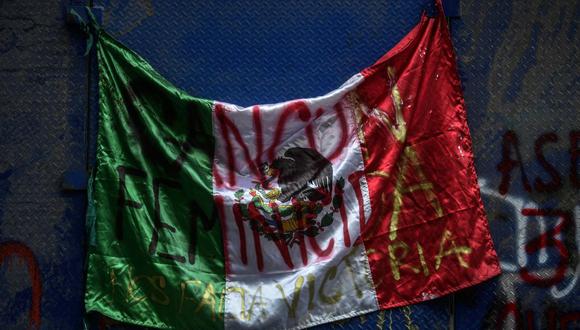 Una bandera mexicana que dice: "Cancún culpable de feminicidio". (Foto de PEDRO PARDO / AFP).