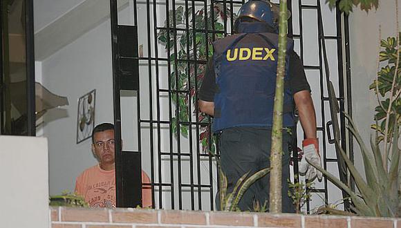 Un agente de UDEX retira una granada que extorsionadores dejaron en casa de un comerciante. (USI)