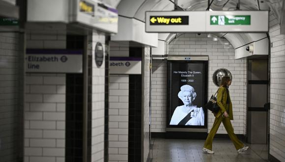 Un peatón pasa junto a un retrato de la reina Isabel II de Gran Bretaña en el metro de Londres el 11 de septiembre de 2022. (Foto de LOIC VENANCE / AFP)