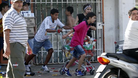 CARGARON CON TODO. Muchos jóvenes protagonizaron los saqueos en los supermercados y tiendas. (AFP)