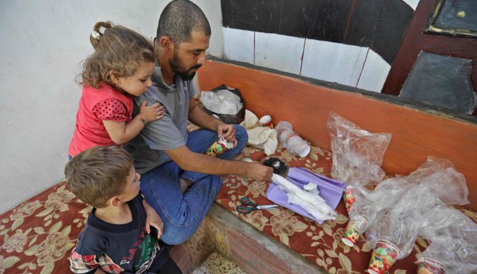 Sirios fabrican máscaras artesanales para proteger a sus hijos de ataques químicos. | Foto: AFP