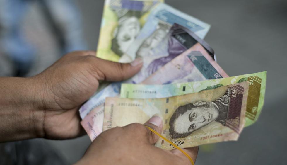 Un hombre muestra los billetes de Bolívar que utilizará para hacer artesanías en una calle de Cúcuta, Colombia, en la frontera con Venezuela. (Foto: AFP)