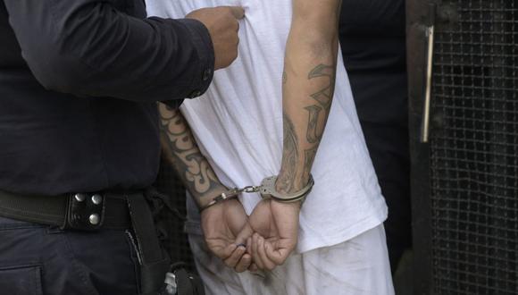 Un hombre capturado por supuestos vínculos con pandillas es escoltado por la Policía Nacional Civil durante el estado de emergencia declarado por el gobierno en San Salvador el 31 de marzo de 2022. (Foto por MARVIN RECINOS / AFP)