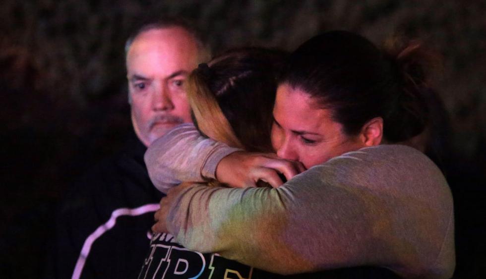 Una mujer que ha huido del lugar del tiroteo, que ha causado al menos 12 muertos, en el Borderline Bar and Grill, abraza a sus familiares en la localidad de Thousand Oaks. (Foto: EFE)