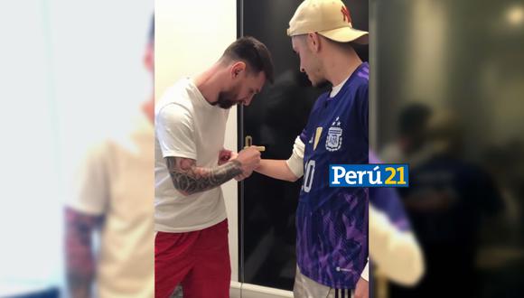 Lionel Messi autografiándole el brazo al hincha que acampó en su casa (Fotos: Juan Polcan).
