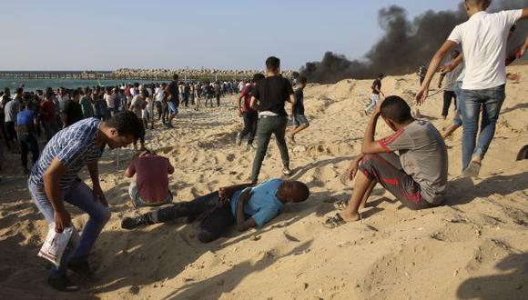 Los manifestantes colapsan después de inhalar gas lacrimógeno durante una protesta en la playa en la frontera con Israel cerca de Beit Lahiya, en el norte de la Franja de Gaza. (Foto: AP)