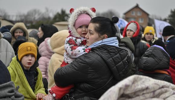 Los refugiados esperan en temperaturas heladas para subirse al autobús, después de cruzar la frontera de Ucrania hacia Polonia, en el cruce fronterizo de Medyka en Polonia, el 7 de marzo de 2022. (Foto: Louisa GOULIAMAKI / AFP)