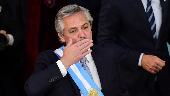 El nuevo presidente de Argentina, Alberto Fernández, da un beso después de recibir la faja presidencial del presidente saliente Mauricio Macri. (Foto: AFP)