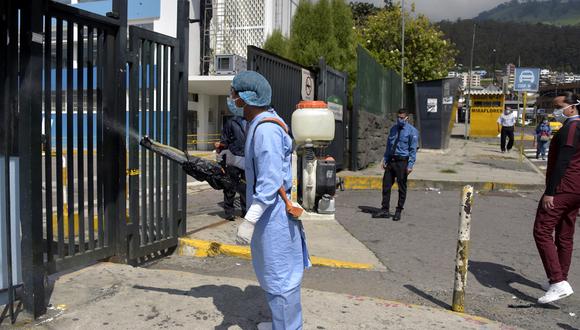 Un trabajador de la salud desinfecta la entrada de emergencia de un hospital en Quito, en medio de la pandemia de coronavirus Covid-19. (Foto: AFP/Rodrigo BUENDIA)