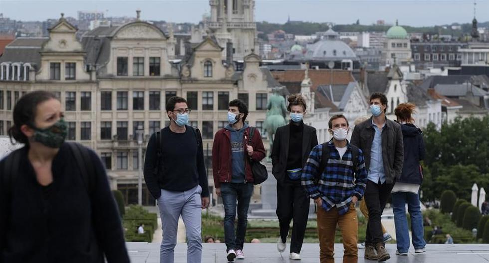 Varias personas con mascarilla para protegerse del coronavirus pasan por la Grand Place de Bruselas. (EFE/EPA/OLIVIER HOSLET).