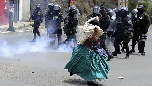 La policía antidisturbios de Bolivia dispara gases lacrimógenos mientras una mujer indígena protesta contra un ataque cívico provocado por el resultado de las elecciones del 20 de octubre. (Foto: AFP)