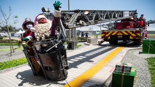 En escalera de bomberos Papá Noel entrega regalos a niños con coronavirus en la Villa Panamericana de Lima